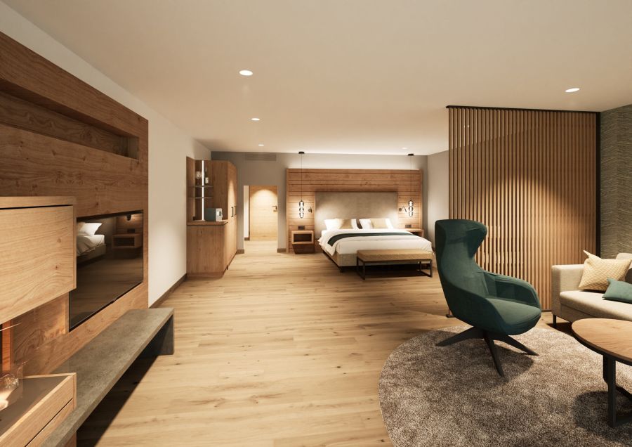 Junior Suite mit Doppelbett, grünem Ohrensessel und heller Holzverkleidung im Hotel Churfürstenhof